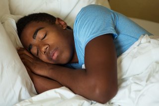 Teen boy asleep in bed